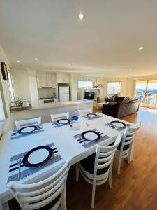 Una mesa de comedor con sillas y una cocina. en Nellies Hideaway 1-20 Troon Drive, en Normanville