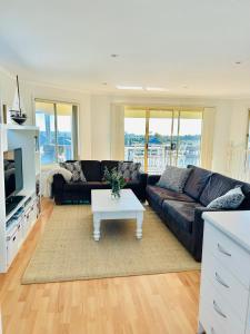 Una sala de estar con un sofá y una mesa de café. en Nellies Hideaway 1-20 Troon Drive, en Normanville