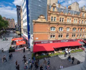 a group of people walking around a street with a building at Central quality point piccadilly in London