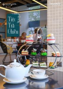 a tea stand with tea cups and cakes on a table at FLC City Hotel Beach Quy Nhon in Quy Nhon