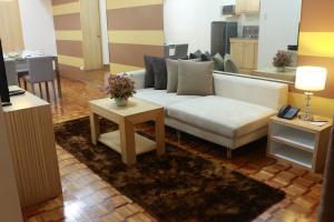 sala de estar con sofá blanco y mesa en Prince Plaza II Condotel, en Manila