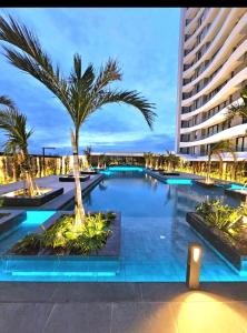 a large swimming pool with a palm tree in front of a building at Santa Cruz de La Sierra - 3 Pago con Qr bedroom luxury apartment in Santa Cruz de la Sierra