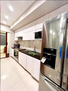 a kitchen with a stainless steel refrigerator and white cabinets at Santa Cruz de La Sierra - 3 Pago con Qr bedroom luxury apartment in Santa Cruz de la Sierra