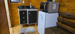 uma cozinha com um lavatório e um frigorífico em Recanto das Folhas - Oásis Pousada em Cambará