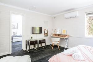 biała sypialnia z biurkiem i łóżkiem w obiekcie Central location 2 bdrm free parking and WiFi w mieście Perth