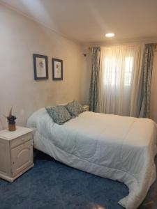 a bedroom with two beds and a nightstand and a bed sidx sidx sidx sidx at la Casita del bosque in Villa Gesell