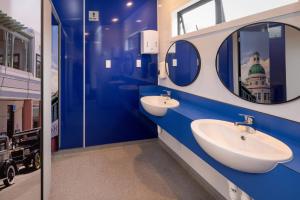 ein blau-weißes Badezimmer mit zwei Waschbecken und Spiegeln in der Unterkunft Napier Beach TOP 10 Holiday Park & Motels in Napier + 42 Fotos