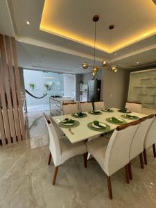 una sala da pranzo con tavolo e alcune sedie di Casa de alto padrão a Natal