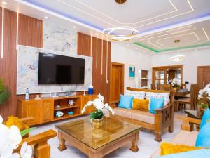 a living room with a couch and a tv at Villa doña kika in San Felipe de Puerto Plata