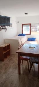 Habitación con 2 camas, mesa y TV. en EDIFICIO NOVOMAR 5to Piso en Mar de Ajó
