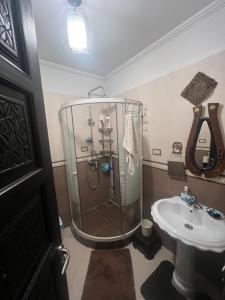 uma casa de banho com um chuveiro e um lavatório. em Yacout Appartement Majorelle em Marrakech