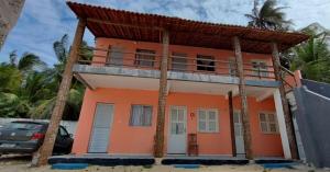 a house on the beach with palm trees at Aloha pousada & restaurante in Itapipoca