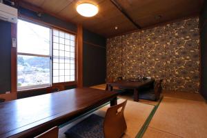 a dining room with a wooden table and a window at 料理旅館ゆり野 in Wajiki