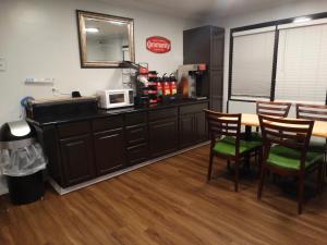 cocina con mesa, sillas y microondas en The Residency Inn en Galveston