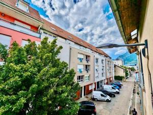 una strada cittadina con auto parcheggiate davanti agli edifici di Grand Studio - Proche Hyper centre - Calme & Tout Equipé a Grenoble
