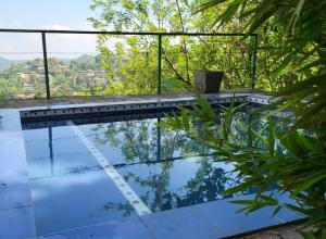 an infinity pool with a view of the trees and mountains at The Kandy House ~ Exclusive Villa in Kandy