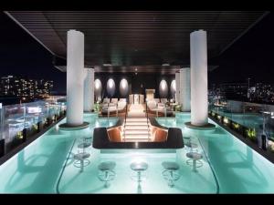 - une piscine avec des chaises et des tables dans un bâtiment dans l'établissement Luxury 1-Bed with Infinity Pool, Gym & Parking, à Brisbane