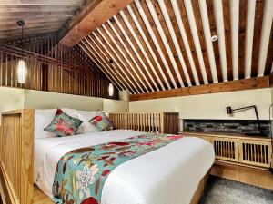 a bedroom with a large bed and wooden ceilings at 北京悦明元星空白塔景观四合院民宿 in Beijing