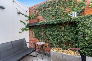 un banc assis devant un mur de briques dans l'établissement MadeComfy Inner City Designer 2-Bed Apartment, à Melbourne