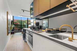 - une cuisine avec un évier et un comptoir dans l'établissement MadeComfy Inner City Designer 2-Bed Apartment, à Melbourne