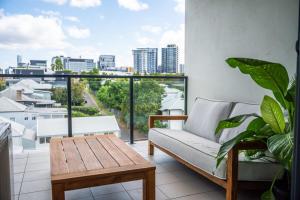a living room with a couch and a table on a balcony at Tranquil 2-Bed Inner City Retreat with Parking in Brisbane