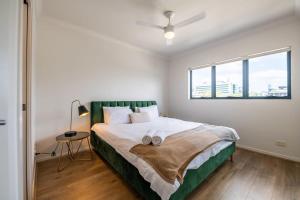 a bedroom with a bed with two towels on it at Tranquil 2-Bed Inner City Retreat with Parking in Brisbane