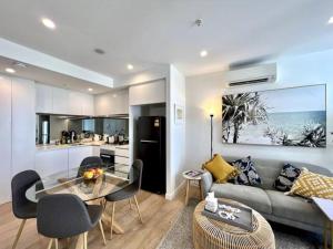 a living room with a couch and a glass table at 2-Bed with Pool, Gym, Parking and Balcony in Brisbane