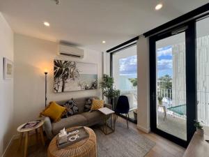 a living room with a couch and a large window at 2-Bed with Pool, Gym, Parking and Balcony in Brisbane