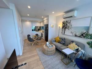 a living room with a couch and a table at 2-Bed with Pool, Gym, Parking and Balcony in Brisbane