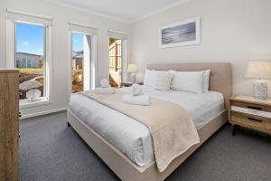 Un dormitorio con una cama grande y una ventana. en Seaslife - Stylish Family Rosebud Accommodation, en Rosebud