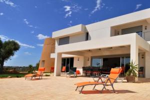 a house with chairs and tables in front of it at Amazing Windmillhouses in Olhão