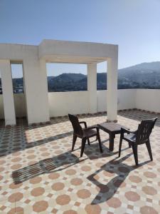 贾姆穆Luxurious Penthouse With a Mountain View的一个带两把椅子和一张桌子的庭院