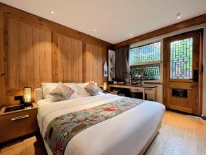 a bedroom with a large bed and a desk at 北京悦明元星空白塔景观四合院民宿 in Beijing