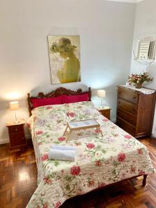 um quarto com uma cama com colcha floral em Apartamento Teresópolis - Centro em Teresópolis