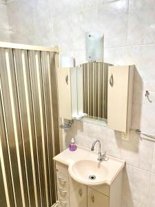 een badkamer met een wastafel en een spiegel bij Apartamento Teresópolis - Centro in Teresópolis