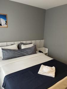 a bedroom with a bed with a towel on it at hihome - Royale in Cabo Frio