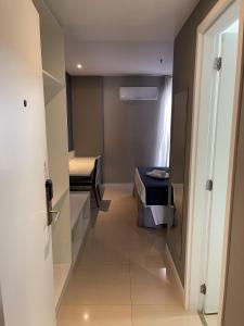a hallway of a room with a bed and a door at hihome - Royale in Cabo Frio