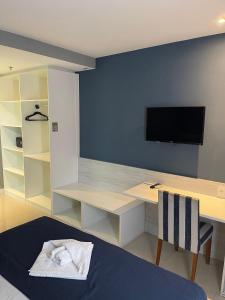 a bedroom with a desk and a tv on a wall at hihome - Royale in Cabo Frio