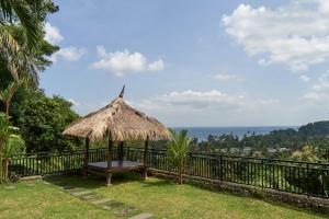 a hut with a bench and a view of the ocean at Attara Hills Sunset Villa Senggigi in Senggigi 