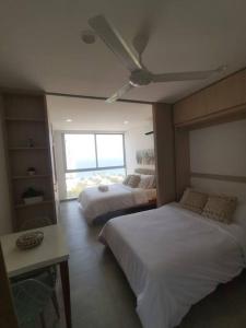 um quarto de hotel com duas camas e uma janela em Apartamento cerca a la Playa em Gaira