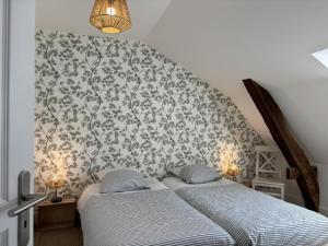 two twin beds in a bedroom with a wall at Duplex de charme au cœur historique de Moulins avec équipements modernes et literie incluse - FR-1-489-523 in Moulins