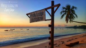 um sinal numa praia com uma palmeira e o oceano em Polly Lodge Bungalow Zanzibar Kiwengwa em Kiwengwa