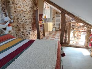 a bedroom with a bed and a stone wall at Chaleureux Gîte avec Terrasse à Proximité de la Loire et des Sites Touristiques - FR-1-590-433 in Bonnée
