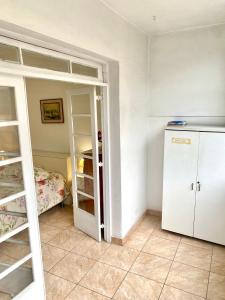 una pequeña cocina con nevera y un dormitorio en Apartamento Teresópolis - Centro en Teresópolis