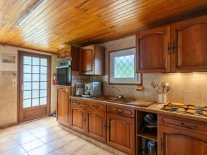 a large kitchen with wooden cabinets and a window at Maison confort 4 pers. proche lac et océan, jardin, WiFi, à Mimizan - FR-1-50-135 in Mimizan