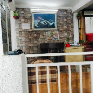 a living room with a fireplace and a stone wall at Jaishnavi Homestay And Restaurant in Mukteswar