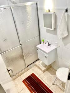 uma casa de banho com um chuveiro e um lavatório. em Apartamento Teresópolis - Centro em Teresópolis