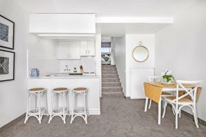 a kitchen and dining room with a table and chairs at Stunning Ocean Views With Manly At Your Doorstep in Sydney