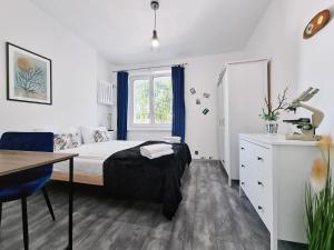 a bedroom with a bed and a desk and a window at CLASSY APARTMENTS - Gdynia - Experyment in Gdynia