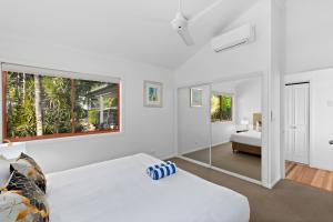 Un pat sau paturi într-o cameră la Heliconia Grove 9 - 2 bedroom - on Hamilton Island by HIHA
